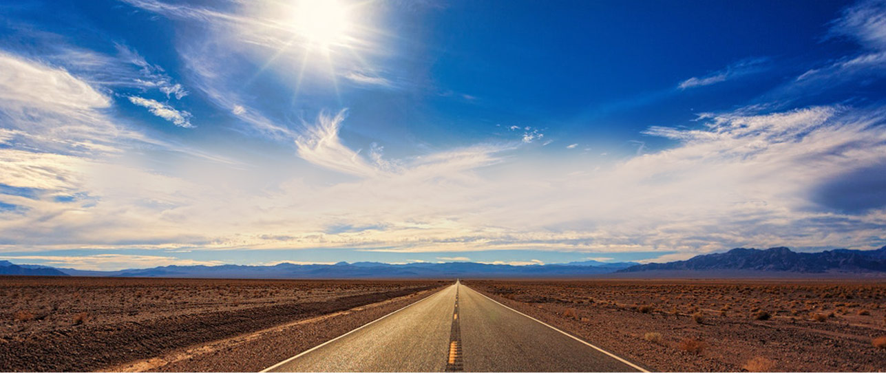 An empty highway road in a desert during the daytime.