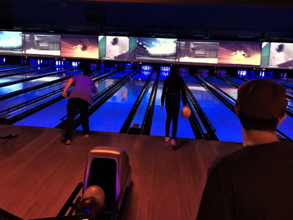 A group of people playing a game of bowling.