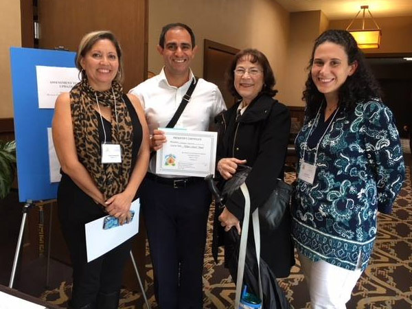 Michael Galvan holds a certificate while posing with other professionals.